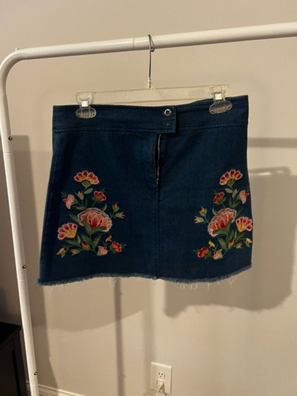 Lightweight jean skirt with embroidered flowers on it